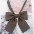Brown JK uniform collar bow detail shot, classic flat lay style, premium fabric accessory. - Coffee