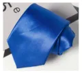 Vue détaillée d'une cravate en polyester bleu uni avec une texture lisse et une forme élégante. - Bleu saphir