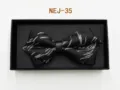 Detailed view of the elegant black bow tie with silver woven pattern inside a gift box. - Black and Silver Texture (NEJ-35)