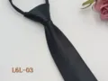 Detail view of black narrow zipper tie fabric texture, classic business formal apparel accessory. - L6L-03