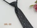Detail view of a men's narrow black zipper necktie featuring a stylish white arrow pattern. - L6L-22