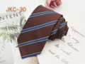 Detail view of brown JK uniform necktie with classic blue and yellow striped jacquard. - JKC-30