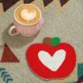 Nahaufnahme des handgemachten perlenbesetzten Apfel-Untersetzers mit weißem Herz, Tischdeko. - Herz Roter Apfel Stil / Rot