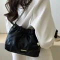 Vue détaillée du sac matelassé noir élégant, montrant une texture exquise et une sangle en cuir. - Noir