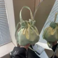 Borsa a secchiello con coulisse in morbido tessuto verde chiaro con motivo sottile per donne. - Verde