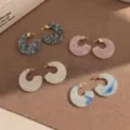 Primo piano di orecchini in acetato colorato a forma di C con dettagli dorati su base. - Fantasia 11
