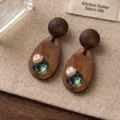 Orecchini in legno fatti a mano con perla naturale e madreperla, scatto di dettaglio vintage. - Stile Perla in Legno