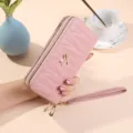 Portafoglio lungo trapuntato rosa da donna con doppia cerniera e comodo cinturino da polso. - Rosa