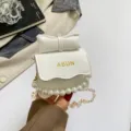 Sac à épaule blanc texturé avec nœud, bordure de perles et bandoulière chaîne, design élégant. - Blanc