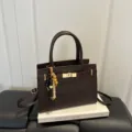 Braune Damen Umhängetasche für Pendler mit Metallverschluss und Perlenanhänger, elegant. - Mit Anhänger / Braun