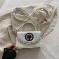 Mini white crossbody shoulder bag with stylish circular metal buckle and chic design. - White