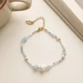 Dettaglio di perline delicate con pietre in vetro blu e ciondolo dorato fatto a mano. - Stile Perline Blu Perla d'Acqua Dolce