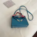 Sac à épaule bleu texturé autruche pour femmes, sac trapèze élégant avec sangle et serrure. - Bleu