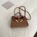 Bolso de hombro de cuero marrón con textura de avestruz, pañuelo de seda y cierre metálico - Marrón