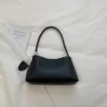 Minimalist black leather underarm shoulder bag for women, stylish commuting handbag. - Black