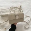 Elegant straw woven shoulder bag in beige with chic metal turn-lock and leather handle. - Off White
