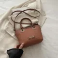 Brown woven bucket bag stylish straw handbag with knot handle and shoulder strap variant design. - Brown