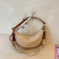 Woven straw crescent shoulder bag with brown leather trim and beige canvas strap for casual wear. - Brown