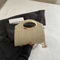 Elegante borsa a tracolla in paglia intrecciata con manico ovale in metallo dorato e catena. - Kaki