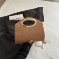 Borsa a mano chic in paglia intrecciata con manico ad anello dorato e catena. - Marrone