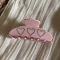 Primer plano de pinza de pelo rosa con corazón de diamantes, detalle de diseño de lunares. - Rosa