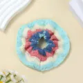 Gedetailleerd overzicht van handgemaakte gehaakte haarelastiek met prachtige gebreide textuur. - Blauw gegolfd haarelastiekje