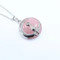 Detailaufnahme des silbernen Mondes und Katzenanhängers mit rosa Rosenquarz Edelstein. - Rosenquarz