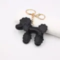 Black leather poodle keychain detail, cute dog bag charm with gold hardware closeup. - Black