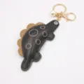Cute dinosaur keychain with leather body and gold clasp, perfect bag charm gift for students. - Black