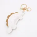 Cute dinosaur keychain bag charm with pearl and metal hardware for backpack decoration. - White