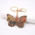 Portachiavi a farfalla in sughero stile vintage con anello in metallo dorato e stampa. - Verde Floreale