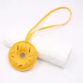 Handmade leather donut charm detail, featuring colorful contrast stitching and a hanging strap. - Strap Style / Yellow