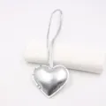 Detail shot of the glossy silver leather heart pendant charm with hanging strap for bags. - Shiny Silver