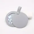 Detail view of portable round leather makeup mirror with LED lights and hanging strap. - Gray