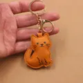 Leuke oranje kat leren sleutelhanger met gouden ring, stijlvolle tas hanger accessoire. - Bruin