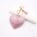 Roze glitter hart leer sleutelhanger detailopname, gouden hardware en leuke pompon. - Roze glitter hart met kwastje