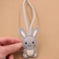 Detailed view of the cute gray PU leather cartoon rabbit bag charm with delicate stitching. - Gray