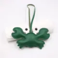 Detailed view of the green leather crab bag charm, featuring fine stitching and loop strap. - Green