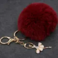 Vista detallada de llavero con pompón de felpa roja y colgante de bailarina con estrás. - Bailarina - Pelo de conejo Rex sintético / Burdeos