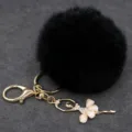 Detalle de primer plano del llavero pompón de felpa negra con colgante de bailarina con estrás. - Bailarina - Pelo de conejo Rex sintético / Negro