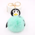 Vista dettagliata del portachiavi con pompon di peluche a forma di pinguino dorato. - Portachiavi Oro / Verde menta
