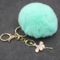 Primer plano del llavero de pompón de felpa verde menta con colgante de bailarina de estrás. - Bailarina - Pelo de conejo Rex sintético / Verde menta