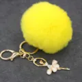 Llavero de pompón de felpa amarilla con colgante de bailarina de diamantes y herrajes dorados. - Bailarina - Pelo de conejo Rex sintético / Amarillo