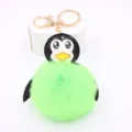 Dettaglio del portachiavi pinguino in peluche verde con pallina soffice e anello dorato. - Portachiavi Oro / Verde fluorescente