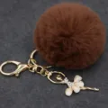 Vista detallada del bonito llavero de bailarina con pedrería y pompón de peluche marrón. - Bailarina - Pelo de conejo Rex sintético / Café