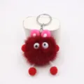 Detailed view of the cute red plush keychain with funny googly eyes and pink bunny ears. - Burgundy