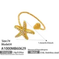 Nahaufnahme des goldenen Edelstahl Stern und Herz Rings mit funkelnden Zirkonia Steinen. - Größe 7 / Seestern-Stil / Weißer Zirkonia