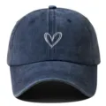 Vue détaillée de la casquette de baseball vintage délavée bleu foncé avec broderie cœur blanc. - Réglable / Bleu marine