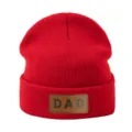 Vista detallada del gorro de punto rojo con un parche de cuero marrón y texto DAD. - Ajustable / Rojo
