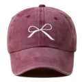 Primer plano detallado de la gorra de béisbol burdeos lavada con un delicado bordado de lazo. - Ajustable / Burdeos